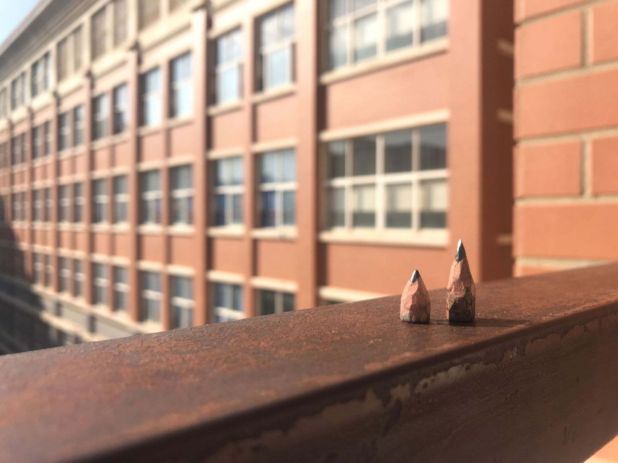Image of two pencil heads in front of a building.